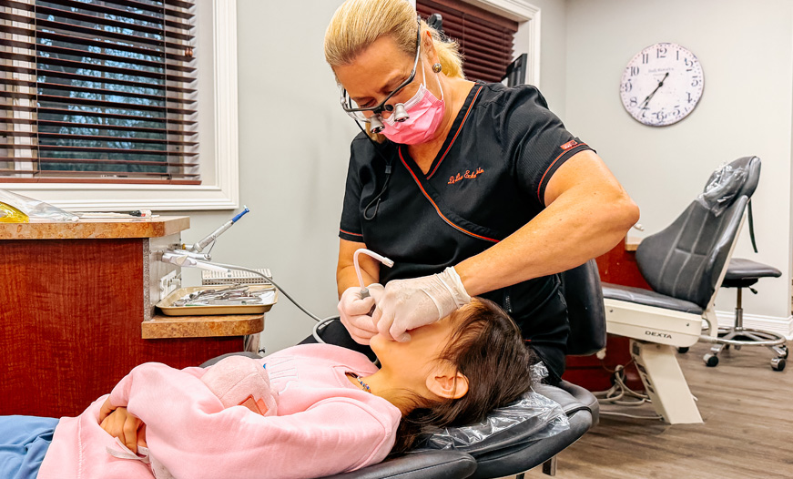 Dr. Lisa with child patient seated at orthodontics appointment