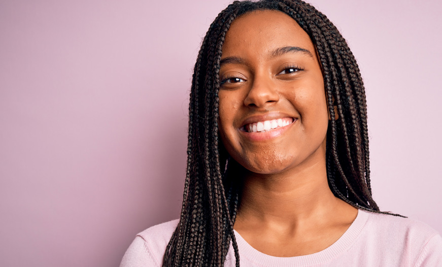 Smiling teen girl on pink background